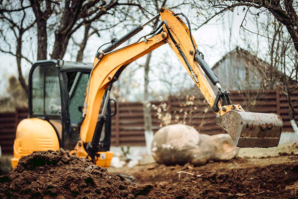 Landschaftsbauarbeiten-mit-Minibagger-auf-der-Baustelle-zu-Hause.-Geländearbeit